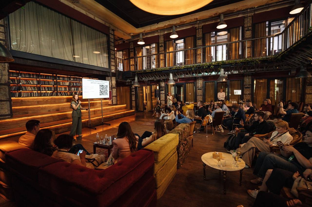 Kateryna Gordiienko, VP de Sucesso do Cliente, apresentando o Happy Hour em Kyiv, junho de 2026